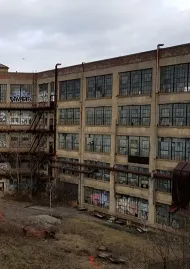 Derelict four-story old Winchester factory with many broken windows
